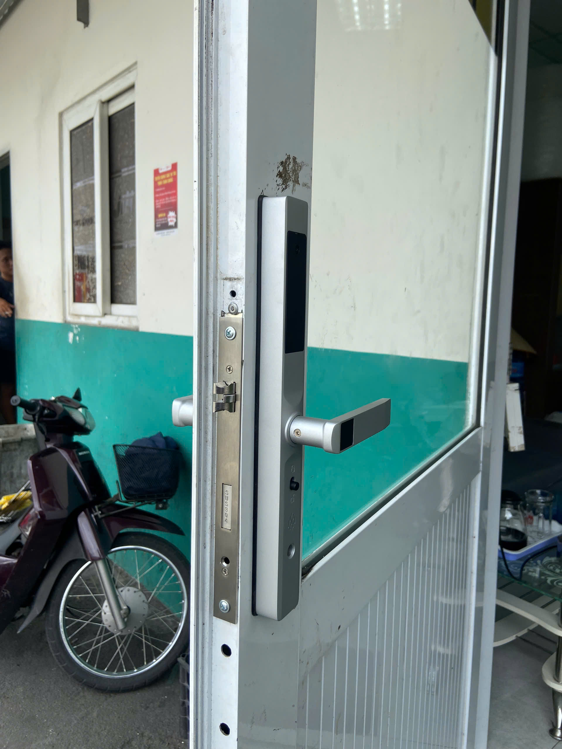 Kỹ thuật viên lắp đặt khóa vân tay Avolock trên cửa nhôm thực tế