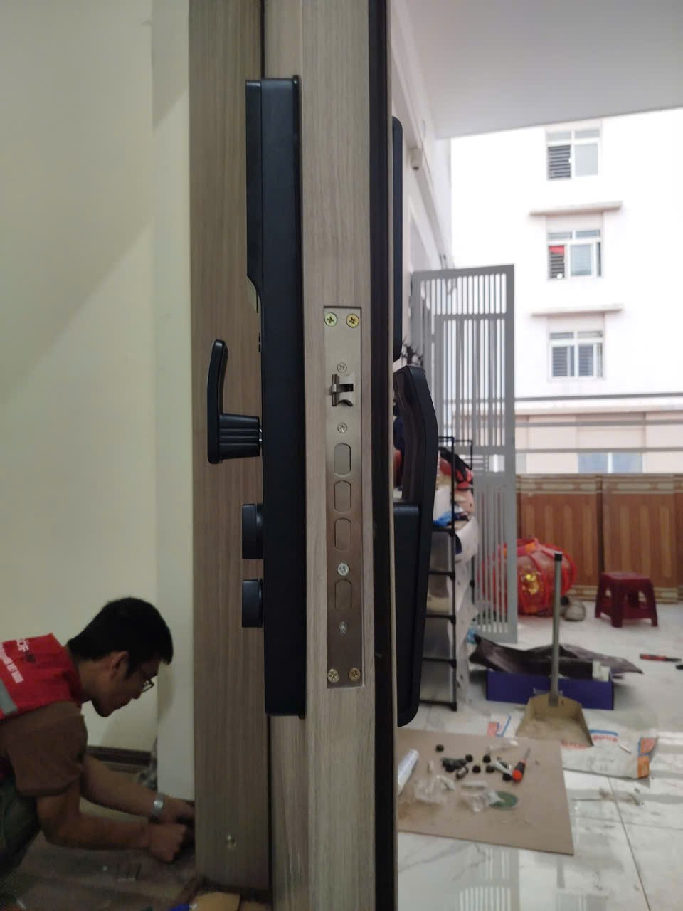 Kỹ thuật viên Avolock đang lắp đặt khóa AL 73FRVT trên cửa gỗ