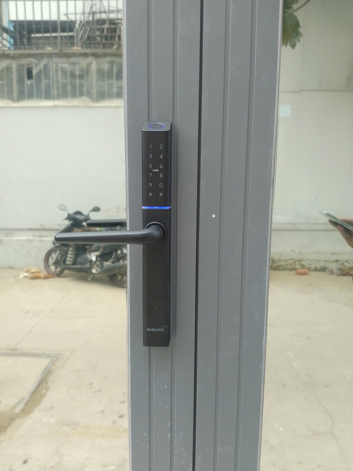 Khóa Avolock AN-395 lắp đặt thực tế trên cửa nhôm kính - mặt trước bàn phím cảm ứng